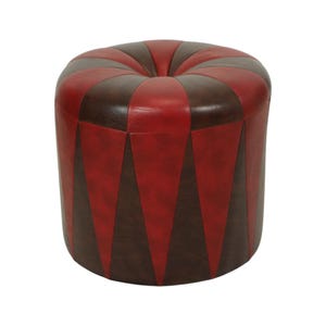 May include: A round, upholstered ottoman with a red and brown color scheme. The top is a series of alternating red and brown curved panels. The sides feature alternating red and brown triangular panels. The ottoman is a decorative furniture piece.