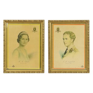 May include: Two framed portraits with gold ornate frames. One portrait features a woman wearing a tiara and necklace. The other portrait depicts a man in a military uniform. Both portraits have text at the bottom.