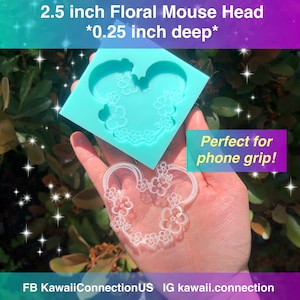 May include: A clear silicone mold for making a 2.5 inch floral mouse head design. The mold is light blue and has a floral pattern around the edges. The mold is perfect for making phone grips.