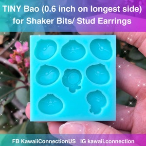 May include: A blue silicone mould with nine cavities shaped like cartoon bao buns. The mould is 0.6 inches on the longest side and is designed for making shaker bits or stud earrings. The text "TINY Bao (0.6 inch on longest side) for Shaker Bits/ Stud Earrings" is at the top of the image. The text "FB KawaiiConnectionUS IG kawaii.connection" is at the bottom of the image.
