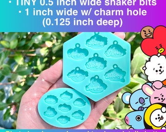 Może przedstawiać: Dwa silikonowe formy do tworzenia zawieszek z żywicy z nazwami członków grupy K-Pop BT21. Formy są jasnoniebieskie i mają kształt chmury wokół każdego imienia. Imię to: Yoongi, Namjoon, Jin, Seokjin, Taehyung, Hoseok i Jungkook. Formy mają 1,27 cm szerokości i 2,54 cm szerokości z otworem na zawieszkę o głębokości 0,32 cm.