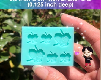 May include: A light blue silicone mold with six butterfly shapes. The mold is 0.5 inches wide and 0.7 inches long. The mold is 0.125 inches deep. The mold is for making shaker bits.