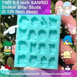 May include: A blue silicone mold with 16 individual compartments, each shaped like a different Sanrio character. The mold is 0.5 inches wide and 0.125 inches deep. The mold is designed for making shaker bits or studs.