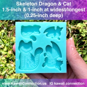 May include: A blue silicone mold with four cavities for making resin crafts. The mold features a skeleton dragon and a skeleton cat. The mold is 1.5 inches wide and 1 inch long at its widest and longest points, and 0.25 inches deep.