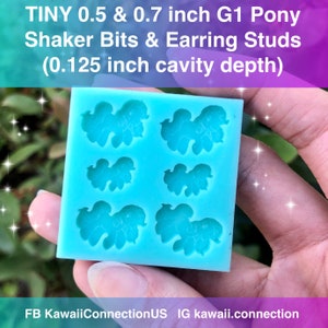May include: A blue silicone mold with six cavities shaped like G1 My Little Pony figures. The mold is designed for making shaker bits and earring studs. The text "TINY 0.5 & 0.7 inch G1 Pony Shaker Bits & Earring Studs (0.125 inch cavity depth)" is printed on the top of the image.
