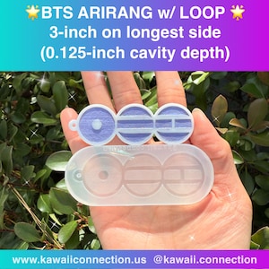May include: A clear silicone mold and a light purple, circular object with the text "BTS ARIRANG w/ LOOP" and measurements of 3-inch on the longest side and 0.125-inch cavity depth. The mold has three circular cavities.