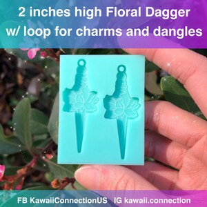 May include: Two 2-inch high floral dagger shaped silicone molds for making earrings. Each mold has a loop at the top for charms and dangles.