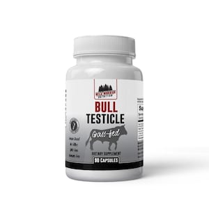 May include: A white plastic bottle of dietary supplement capsules. The label reads "BULL TESTICLE" with a graphic of a bull and the words "Grass-fed". The bottle contains 90 capsules and is from Wild Warrior Nutrition.