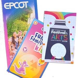 An Epcot guide map, a Fun for Families with Kids guide, and a Festival of the Arts festival passport are grouped together.