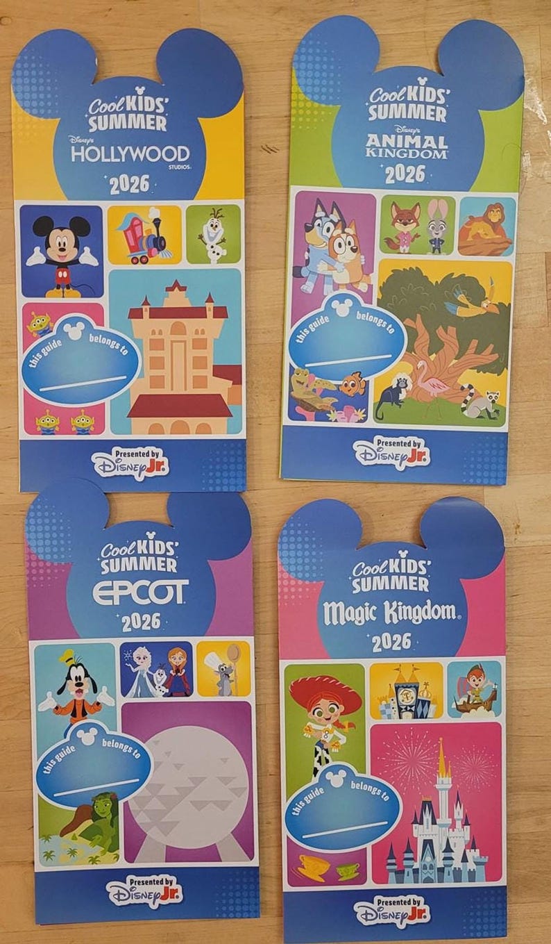 Four Cool Kids Summer 2026 guide maps for Hollywood Studios, Animal Kingdom, Epcot, and Magic Kingdom are arranged on a wooden surface.