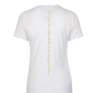 Könnte beinhalten: Weißes T-Shirt mit einer goldenen Aufschrift auf der Rückseite, die lautet: "Gott gibt seine härtesten Schlachten seinen stärksten Soldaten."