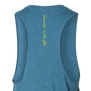 May include: A blue sleeveless tank top with the text "Surrender to the flow" printed in yellow on the back.