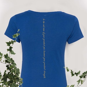 May include: A royal blue t-shirt with a gold inscription on the back that reads "In the end some of your greatest pain becomes your greatest strength."