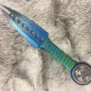 May include: A blue and green dagger with a black handle and a silver crow pentagram on the pommel.