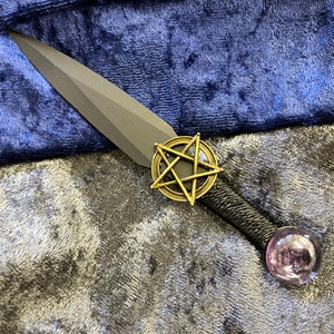 May include: A black dagger with a pentagram design and a clear crystal ball at the end of the handle.