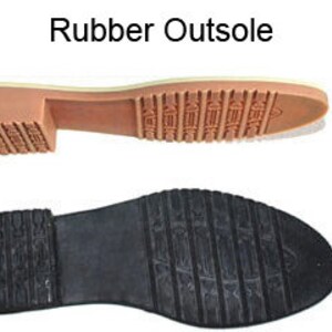 May include: Close-up of a rubber outsole for a shoe. The outsole has a textured pattern and a light brown color.