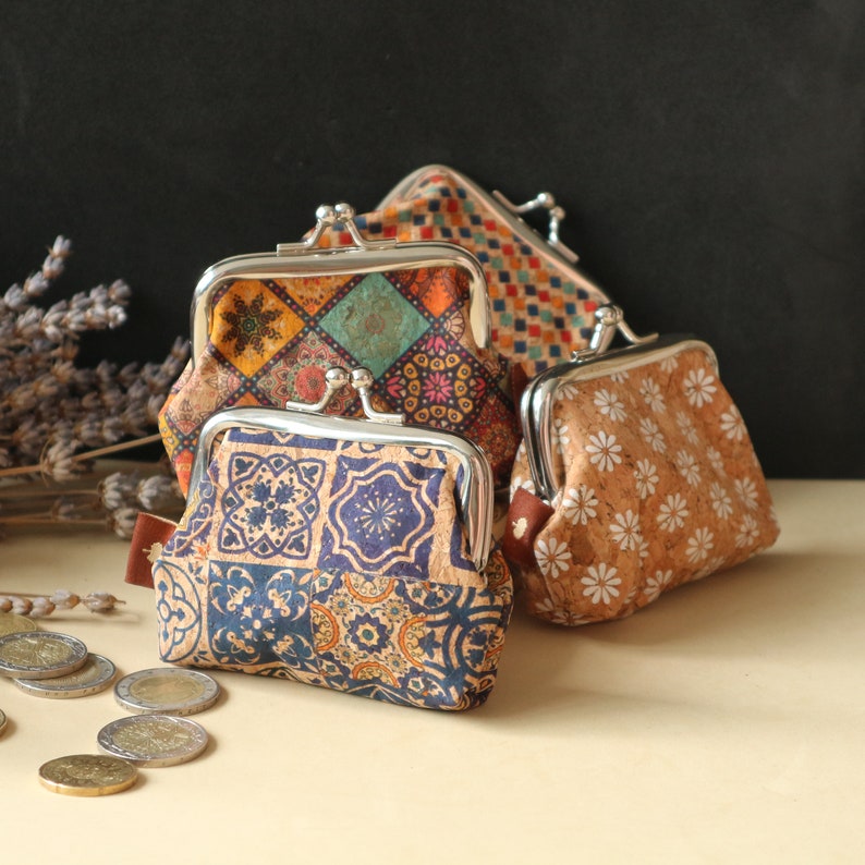 May include: Three small coin purses with different patterned designs. The purses are made of cork and have a metal frame. The patterns are geometric, floral, and a mix of both.