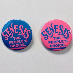May include: Two round blue and pink buttons with the text "Genesis The People's Choice." in pink and blue lettering.