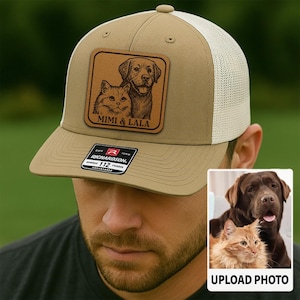 May include: Tan and white trucker hat with a brown leather patch featuring a cat and dog portrait and the text "MIMI & LALA". The hat has a curved brim and a mesh back. The hat also has a small tag that says "RICHARDSON 112".