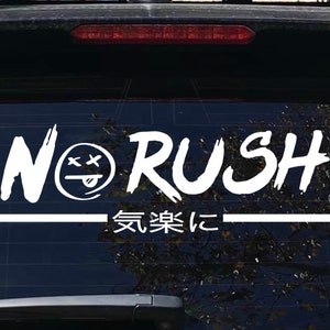 May include: White vinyl sticker with the words "No Rush" in a stylized font. A cartoon face with crossed eyes and a tongue sticking out is between the words "No" and "Rush". Below the words is a line and the text "気楽に" in Japanese.