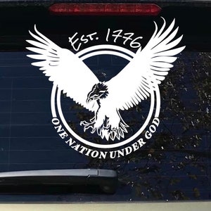 Puede incluir: Calcomanía de vinilo blanco con un águila calva en vuelo dentro de un círculo. El círculo tiene el texto "Est. 1776" en la parte superior y "One Nation Under God" alrededor de la parte inferior.