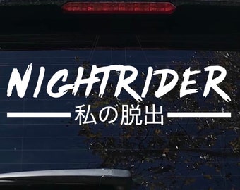 May include: White vinyl sticker with the words "NIGHTTRIDER" and the Japanese text "私 の 脱出" which translates to "My Escape" on a black car window.