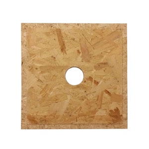 May include: A square piece of chipboard with a round hole in the centre. The board is light brown and has a rough texture.