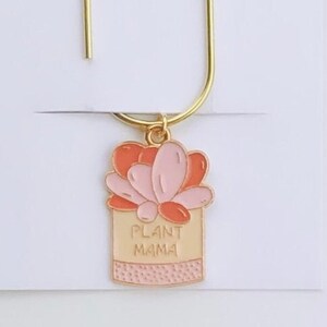 May include: Gold bookmark with a pink and orange enamel charm that says "Plant Mama".