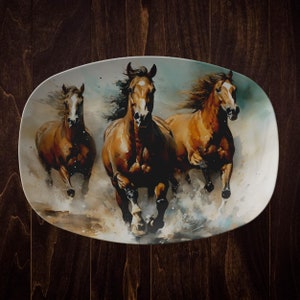 May include: A ceramic oval serving platter with a watercolor painting of three brown horses running through a field of water. The horses are in motion with their manes flowing in the wind.