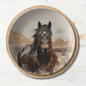 May include: A black horse with a red and white headband runs through a desert landscape. The horse is depicted on a round ceramic plate with a woven straw border.