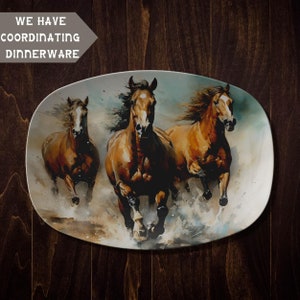 May include: A white oval serving platter with a watercolor painting of three brown horses running through a field of water. The horses are in motion with their manes flowing in the wind.