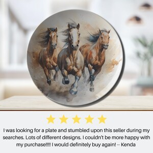May include: A white ceramic plate with a watercolor painting of three brown horses running. The horses are painted in a realistic style with details of their manes and tails.