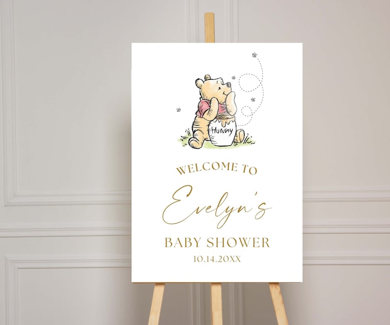 May include: A Winnie the Pooh baby shower welcome sign with a cartoon illustration of Winnie the Pooh holding a honey pot. The sign says "Welcome to Evelyn's Baby Shower 10.14.20XX".