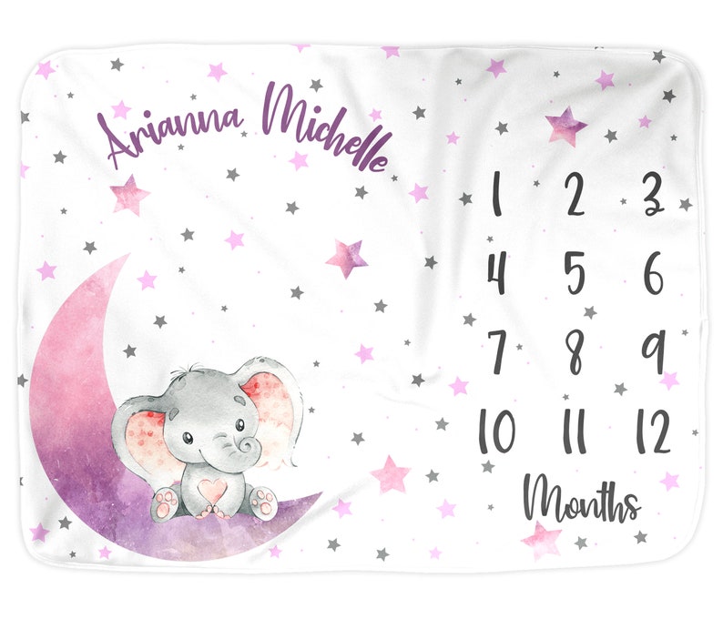 Puede incluir: Una manta de beb&eacute; blanca con una luna creciente rosa y morada y un elefante gris sentado sobre ella. La manta est&aacute; decorada con estrellas rosas y grises y el texto "Arianna Michelle" y "1 2 3 4 5 6 7 8 9 10 11 12 Meses".