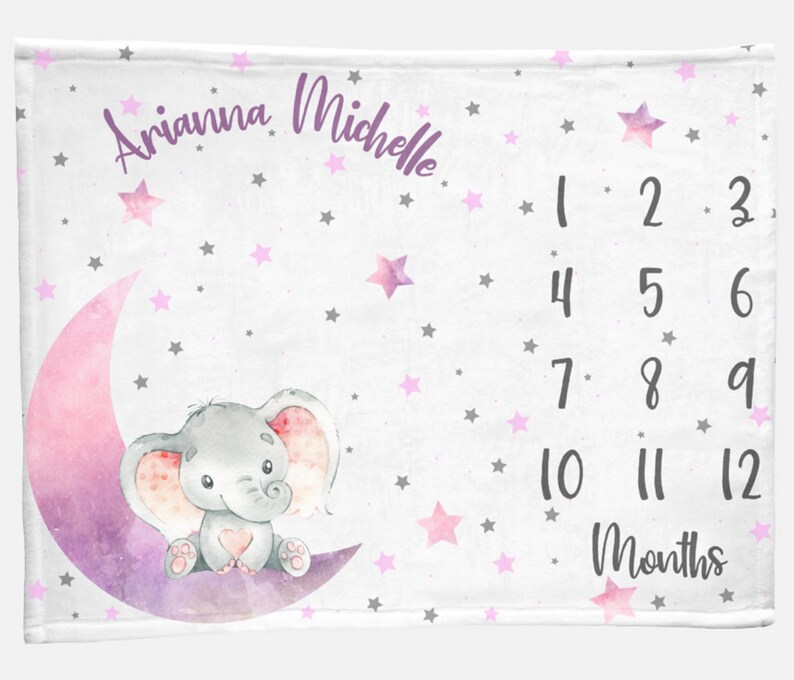 Puede incluir: Una manta blanca para hitos de beb&eacute; con una luna creciente rosa y morada y un elefante gris sentado sobre ella. La manta est&aacute; decorada con estrellas rosas y grises. El texto "Arianna Michelle" est&aacute; escrito en la parte superior de la manta. Los n&uacute;meros del 1 al 12 est&aacute;n impresos en el lado derecho de la manta, con la palabra "Meses" debajo.