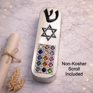 Puede incluir: Estuche de mezuzá plateado con una Estrella de David y una letra hebrea. El estuche está adornado con gemas de colores. Un rollo y espigas de trigo están junto a la mezuzá. El texto en la imagen dice "Non-Kosher Scroll Included."