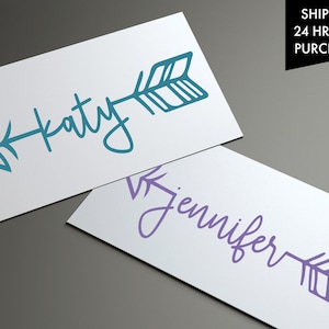 May include: Two white cards with a teal arrow and the name "Katy" on one card and a purple arrow and the name "Jennifer" on the other card.