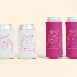 May include: White and fuchsia can coolers with a bow and ribbon design. The text "She's tying the knot!" and "05 17 27" are printed on the coolers. The words "Diana's Bridal Shower" are also printed on the coolers.