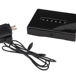 May include: A black acrylic display base with a built-in LED light strip. The base is powered by a black AC adapter with a cord.