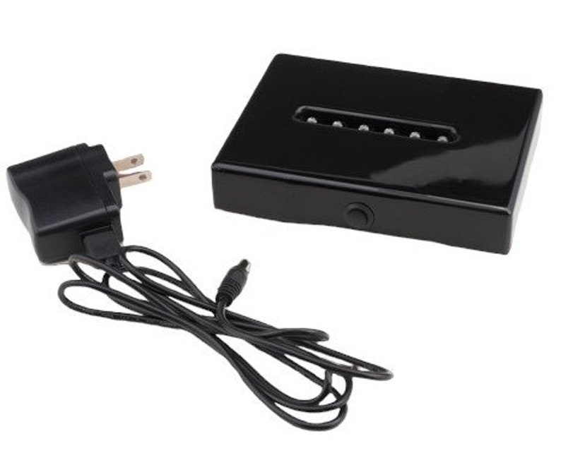May include: A black acrylic display base with a built-in LED light strip. The base is powered by a black AC adapter with a cord.