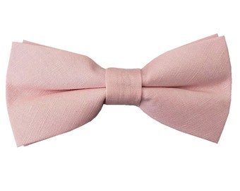 May include: A light pink bow tie made of fabric.