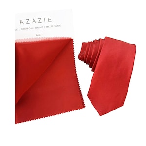 Puede incluir: Una muestra de tela roja con el texto "AZAZIE LLE / CHIFFON / LINING / MATTE SATIN Rust" y una corbata de satén roja.