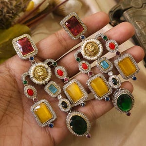 May include: A white ceramic mug with a black handle and the text "But First, Coffee" in a bold, black font. The mug is set against a neutral background, highlighting its simple design.