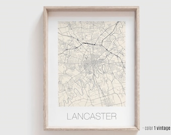 Może przedstawiać: Winylowy wydruk mapy Lancaster, Pensylwania. Mapa jest czarno-biała z kremowym tłem. Tekst "LANCASTER" jest wydrukowany na czarno na dole mapy. Tekst "color 1 vintage" jest wydrukowany na czarno w prawym dolnym rogu mapy. Mapa jest oprawiona w jasną drewnianą ramę.