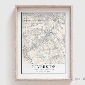 May include: A vintage style map print of Riverside, California. The map shows the city streets and landmarks in black and white with a light blue water feature. The text "Riverside, California 33°56'53"N / 117°23'46"W" is printed below the map.