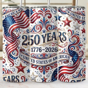 May include: A white tumbler with a patriotic design celebrating 250 years of the United States of America. The design features the American flag, stars, and the text "250 YEARS 1776-2026 UNITED STATES OF AMERICA" in red, white, and blue.