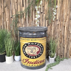 May include: A cylindrical metal storage container with a lid, featuring a yellow and maroon Indian Motorcycle logo with the text America's First Motorcycle Company and 1901. The container has a distressed finish and a circular grey top lid.