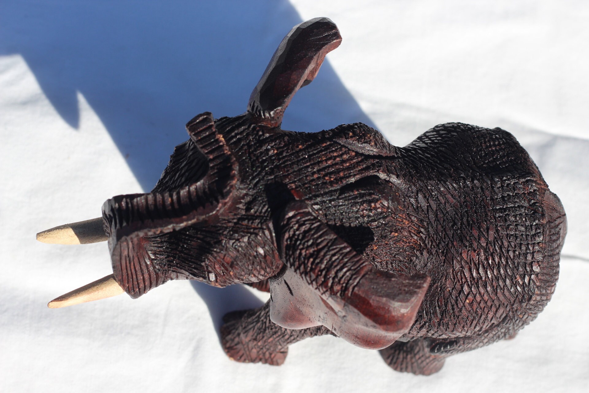 ジンバブエ産ムクワ材の手彫り象の鼻飾り（鼻の上）。ダークブラウンの