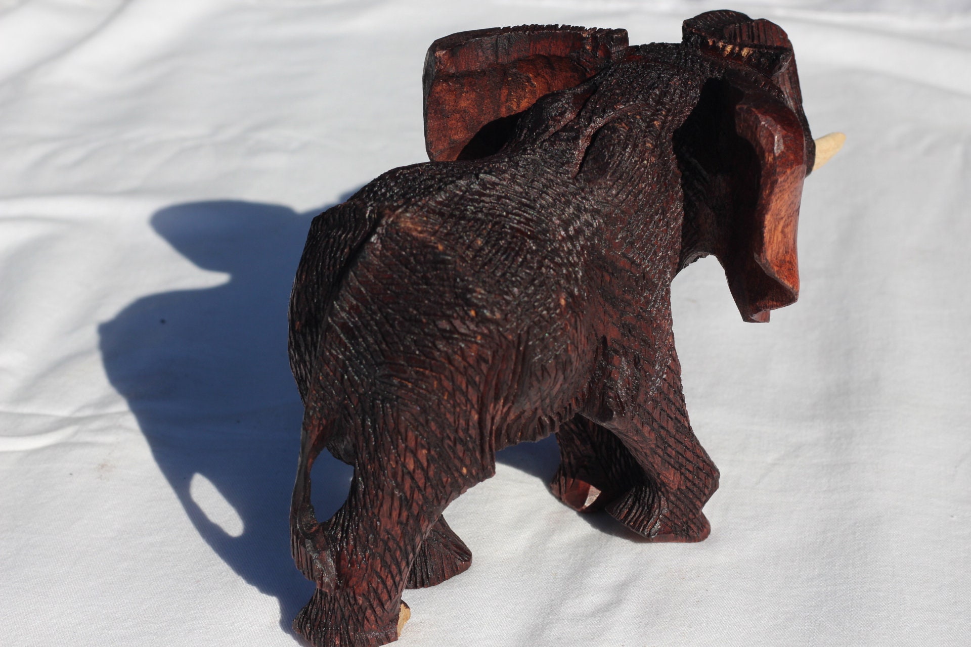 ジンバブエ産ムクワ材の手彫り象の鼻飾り（鼻の上）。ダークブラウンの