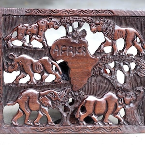 Cinco Grandes Animales Africanos tallados en un panel decorativo rectangular. Con mapa africano en el centro y adorno artístico de hierro y madera. Listo para enviar como regalo.